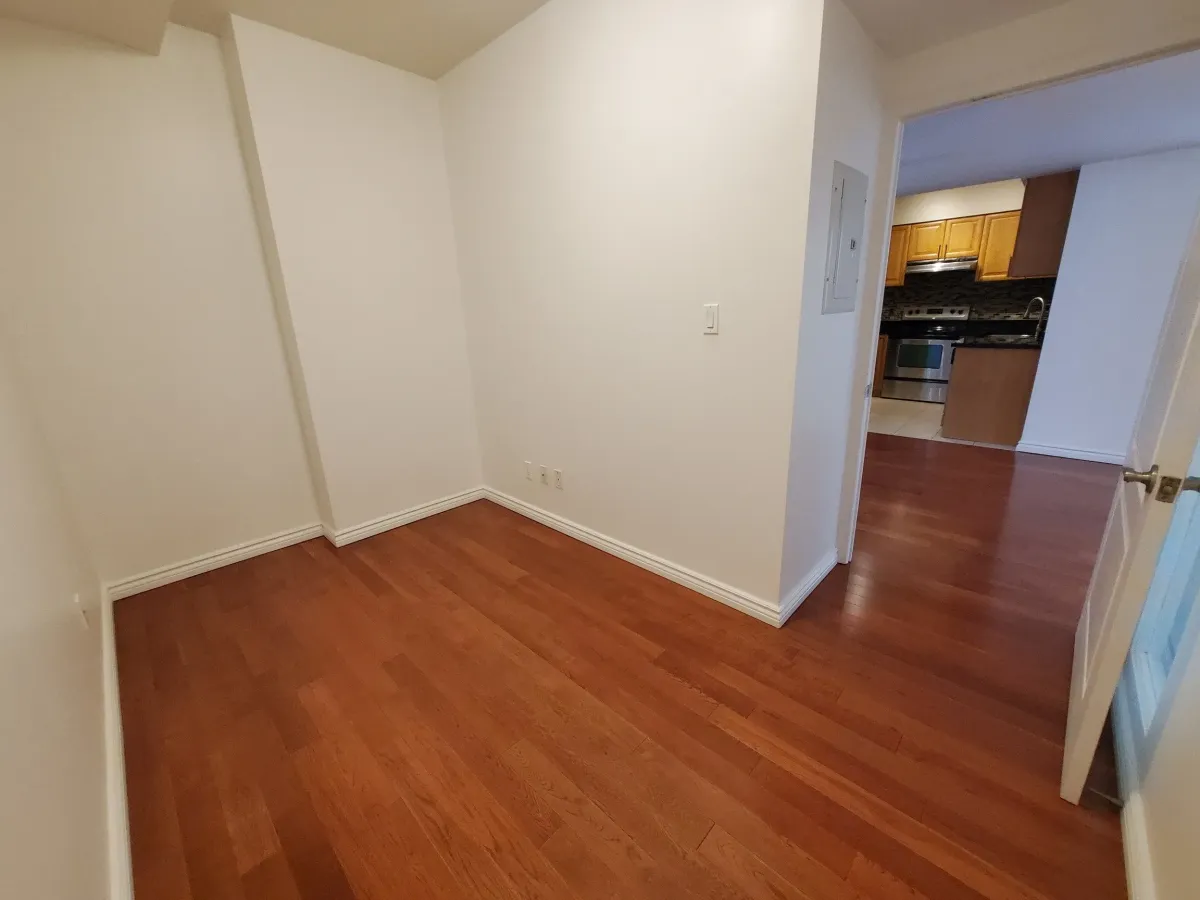 Sun-filled master bedroom at 263 Wellington St W, Unit 701 with large windows and hardwood floors.