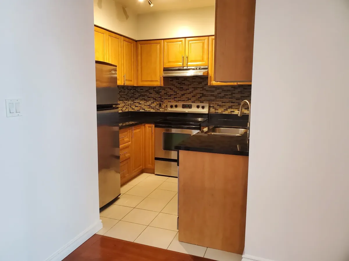 Close-up of the granite counters and stainless steel fridge at 263 Wellington St W, Unit 701.