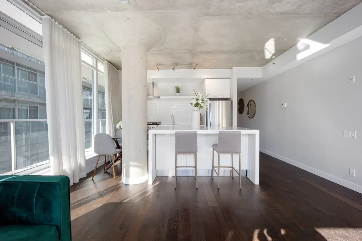 Sun-drenched living room at 75 Portland St #807, highlighting the 950+ sq. ft. open-concept layout and hardwood floors.