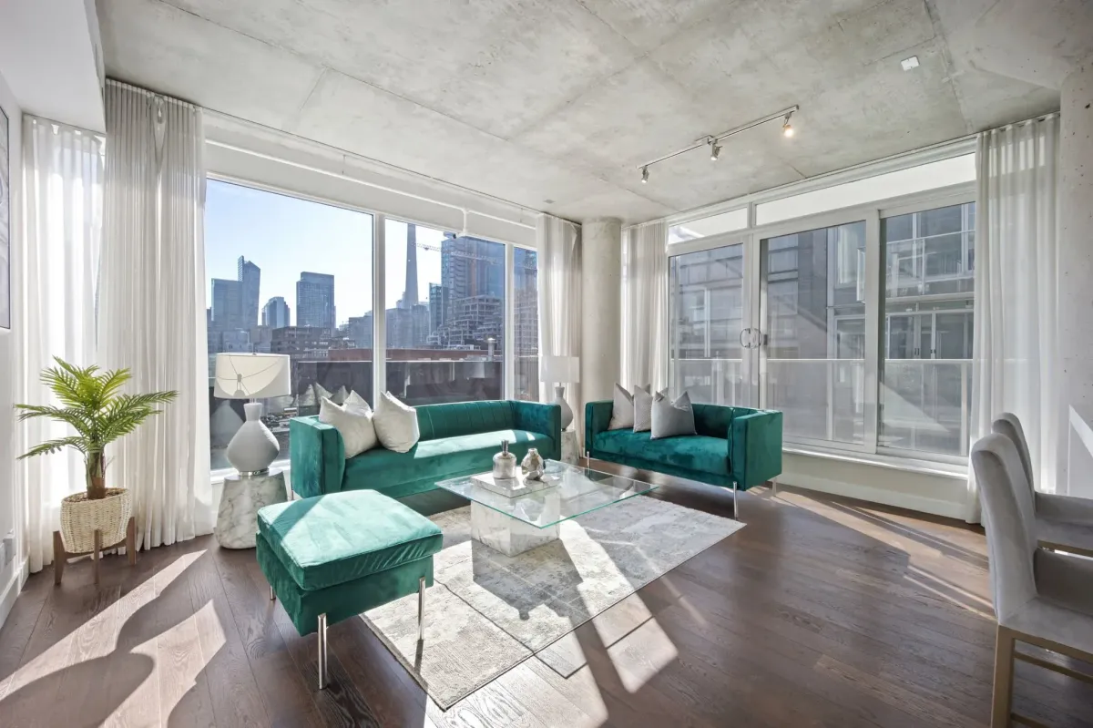 Corner-unit living room perspective at 75 Portland St #807, showcasing the unobstructed view of the CN Tower.