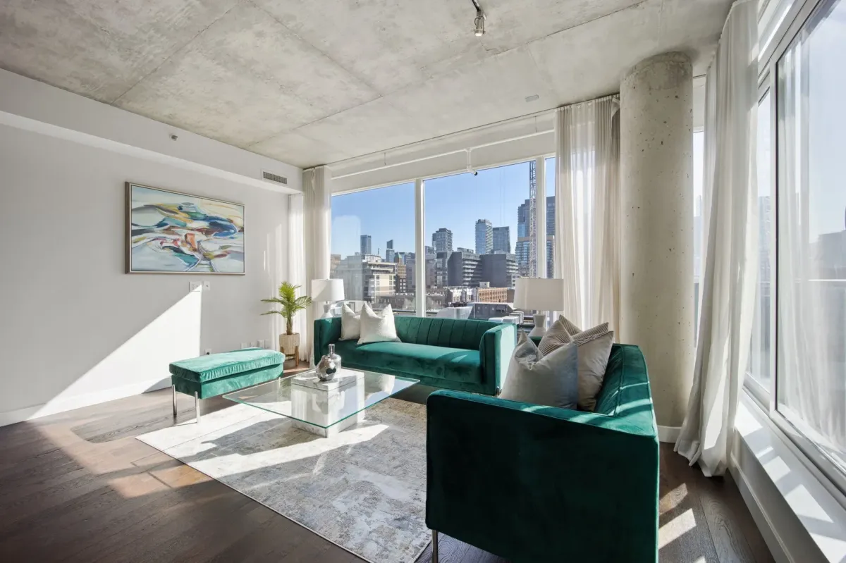 Floor-to-ceiling windows in the corner-unit living room at 75 Portland St #807, flooding the space with natural light.