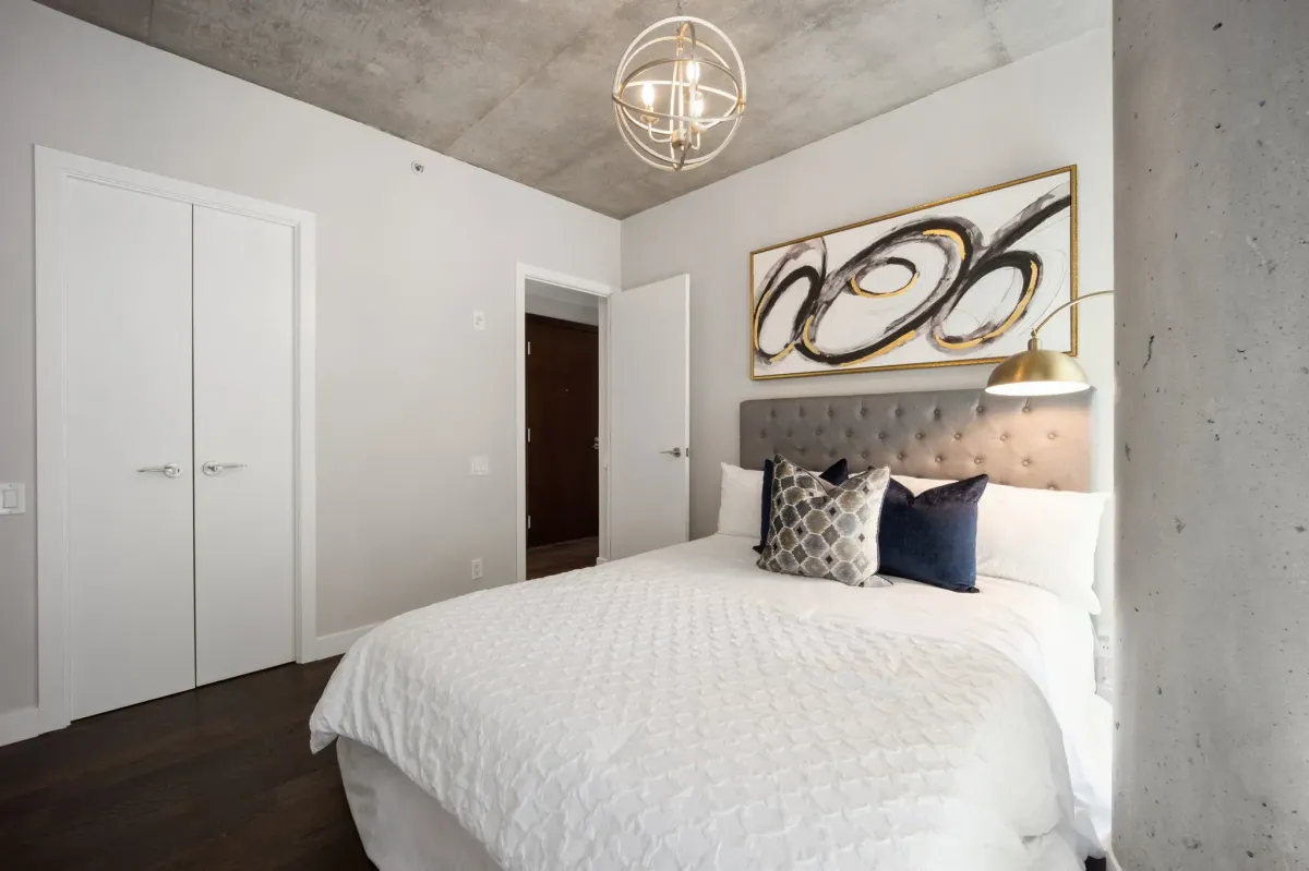 Principal bedroom at 75 Portland St #807, featuring modern decor, concrete accents, and a large walk-in closet.