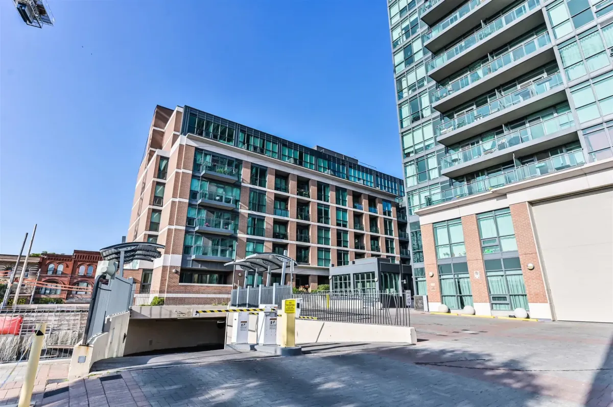 Exterior view of the mid-rise building at 1169 Queen St W, Unit N502, showcasing the Bohemian Embassy’s brick architecture.