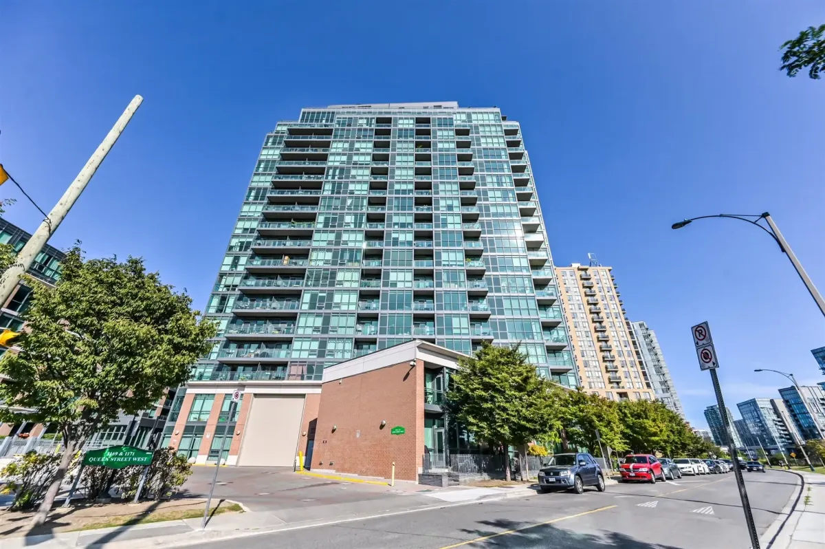 Modern loft-style living room in Unit N502, 1169 Queen St W, featuring concrete ceilings and minimalist decor.