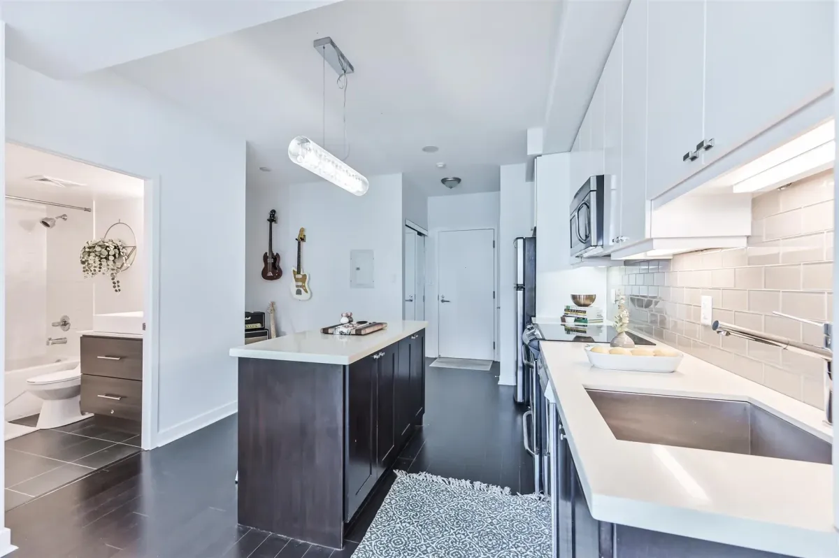 Bright bedroom in Unit N502, 1169 Queen St W, featuring concrete ceilings and large window.