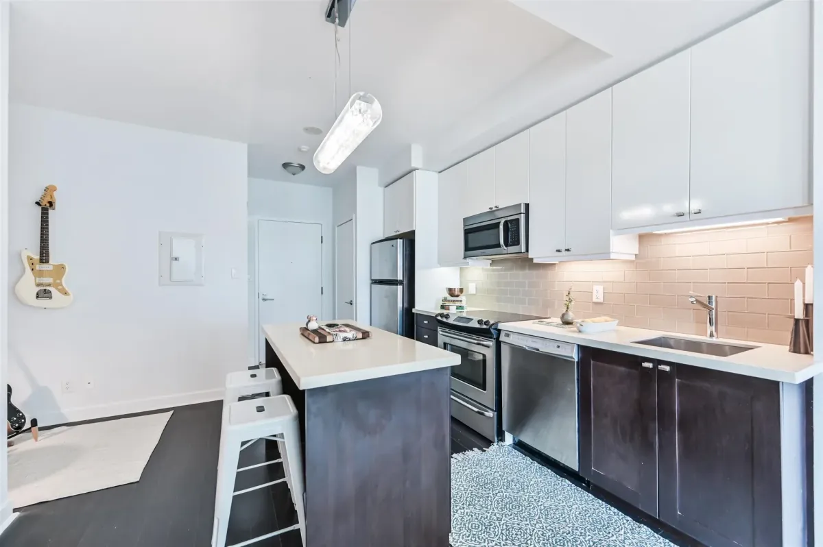 Sleek kitchen area at 1169 Queen St W, Unit N502, featuring premium stainless steel appliances and open shelving.