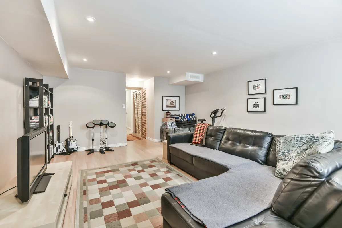 Cozy secondary seating area or den at 9 Algarve Cres, featuring a modern grey sectional and accent rug.