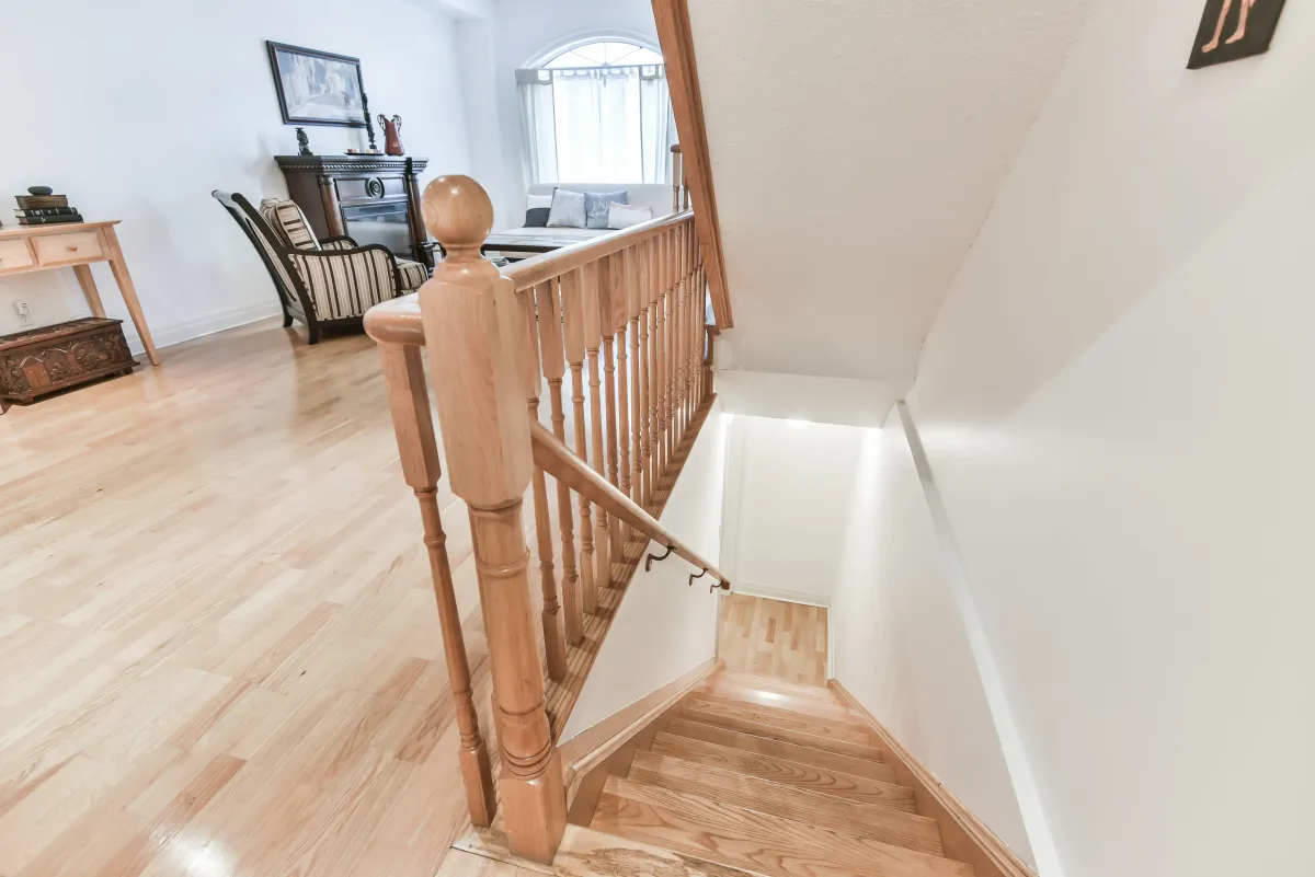 View from the main floor looking up the wooden staircase at 9 Algarve Cres, highlighting the architectural skylight.