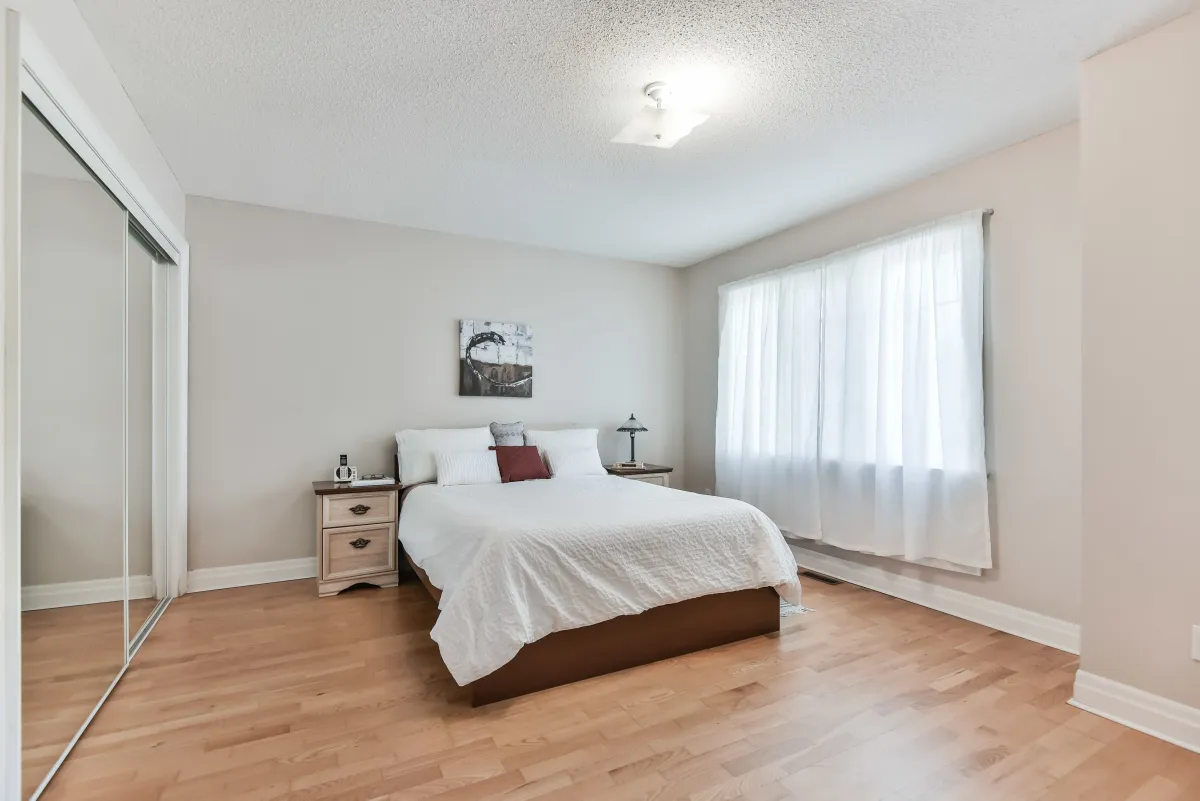 Comfortable third bedroom at 9 Algarve Cres, highlighting the home's consistent hardwood floors.