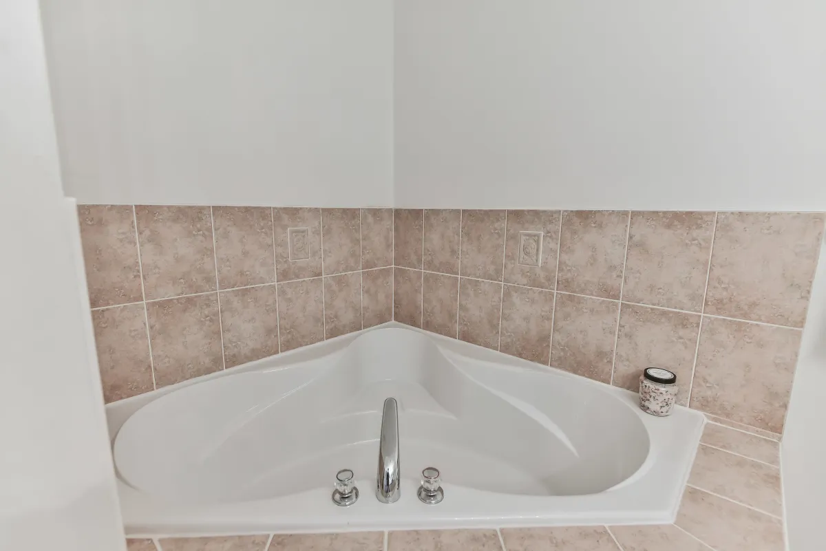 Spa-like bathroom at 9 Algarve Cres, featuring a large corner soaking tub and neutral tile work.