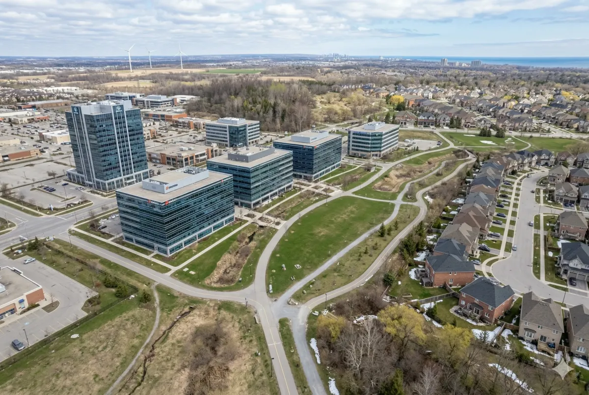 Aerial view of the Burlington Corporate Corridor along the QEW, featuring modern commercial office buildings, professional business parks, and transit-oriented development in Burlington, Ontario.