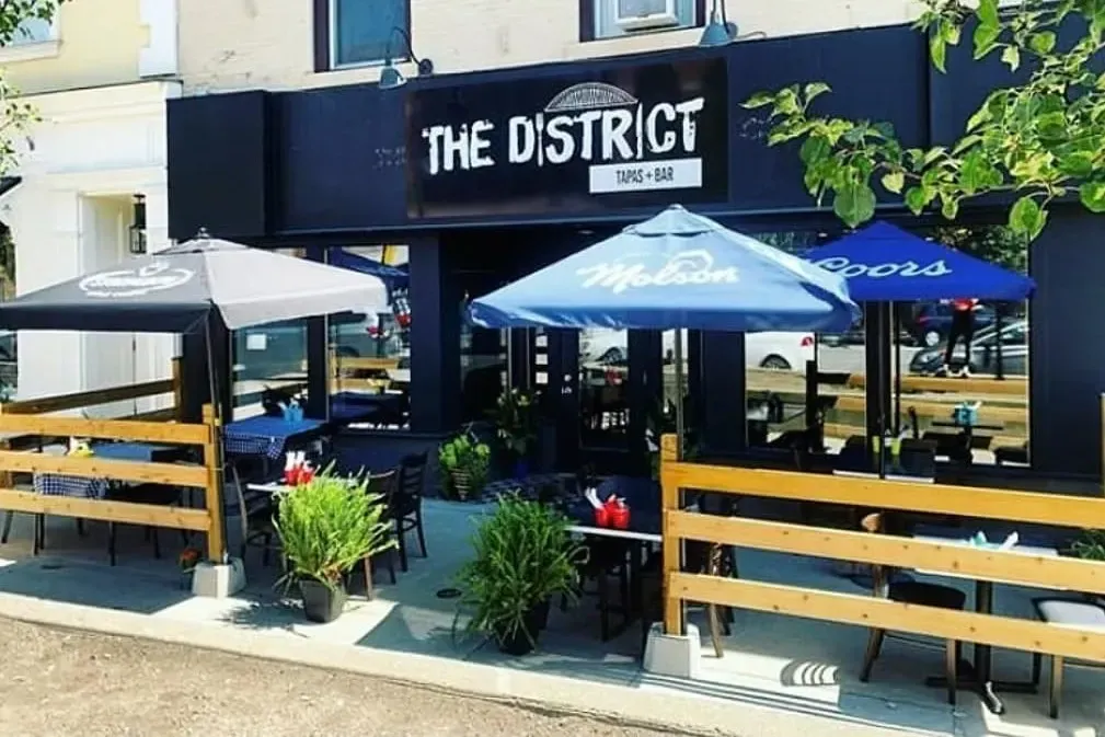 The outdoor seating area and signage for The District Tapas and Bar.