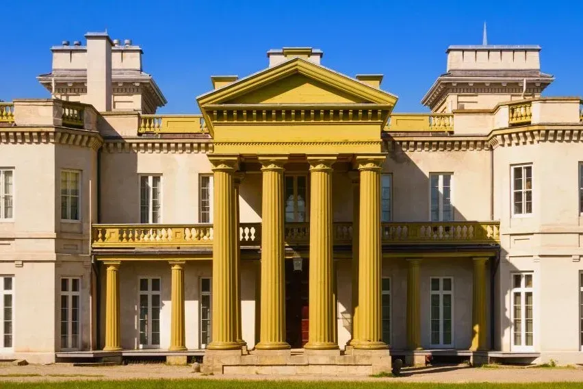 The historic grand facade and yellow columns of Dundurn Castle in Hamilton.