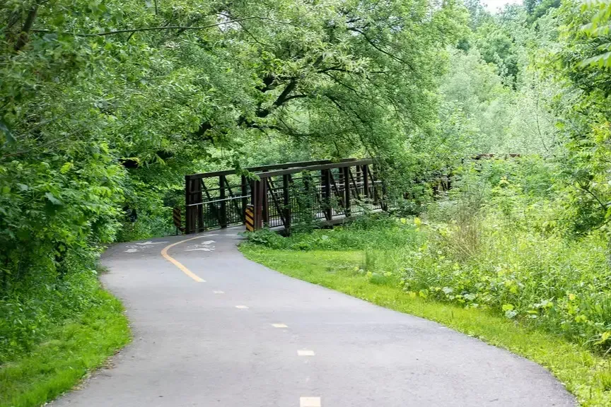 A paved walking and biking trail surrounded by lush greenery in Mississauga.