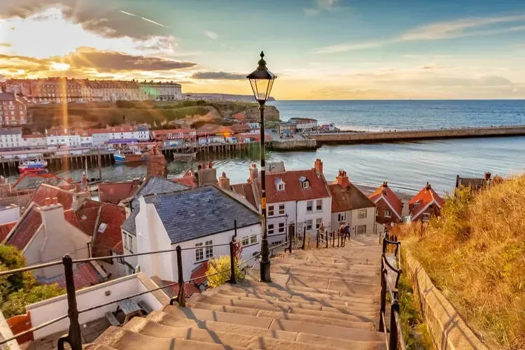A beautiful sunset view over the Whitby pier and waterfront walking paths.
