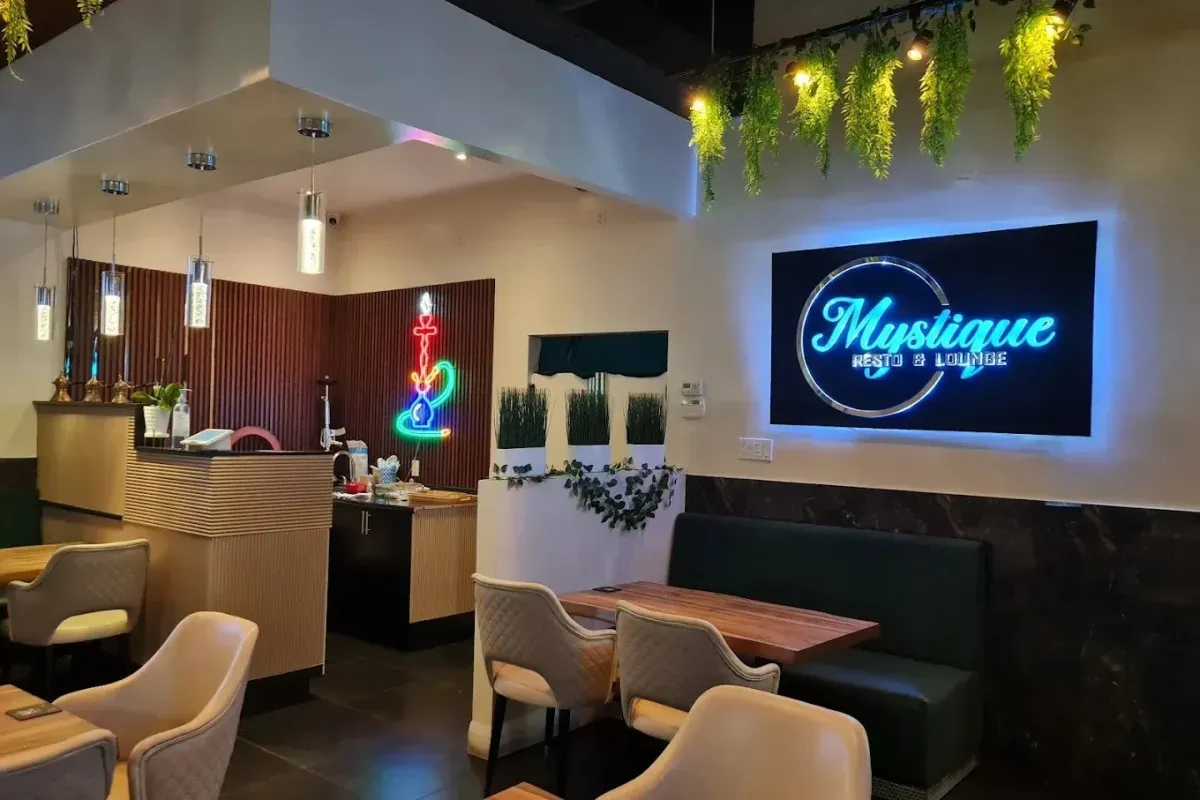 Modern interior and bar area of Mystique Resto and Lounge featuring neon signage.