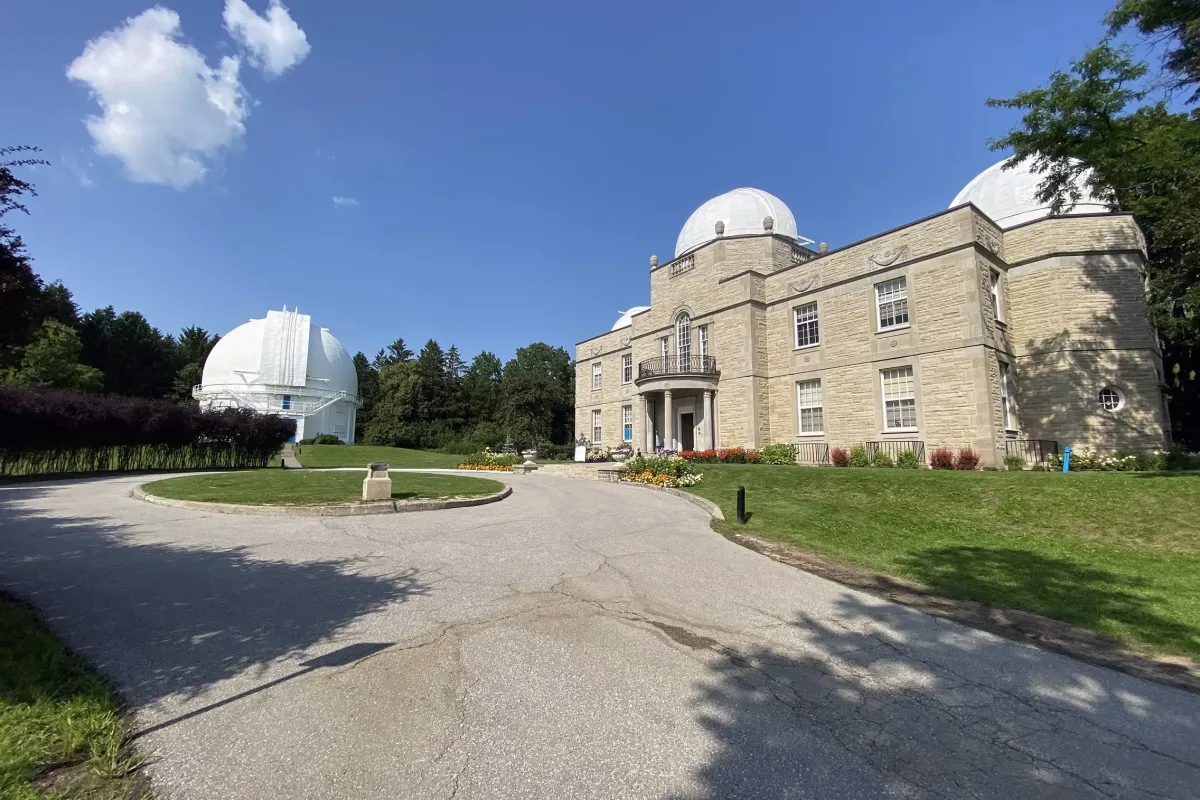 The historic David Dunlap Observatory building under a clear blue sky in Richmond Hill.