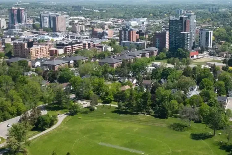 Aerial panoramic view of the Waterloo city skyline and green spaces.