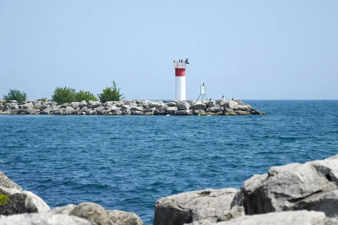 The white and red lighthouse at Bronte Harbour on a clear day.