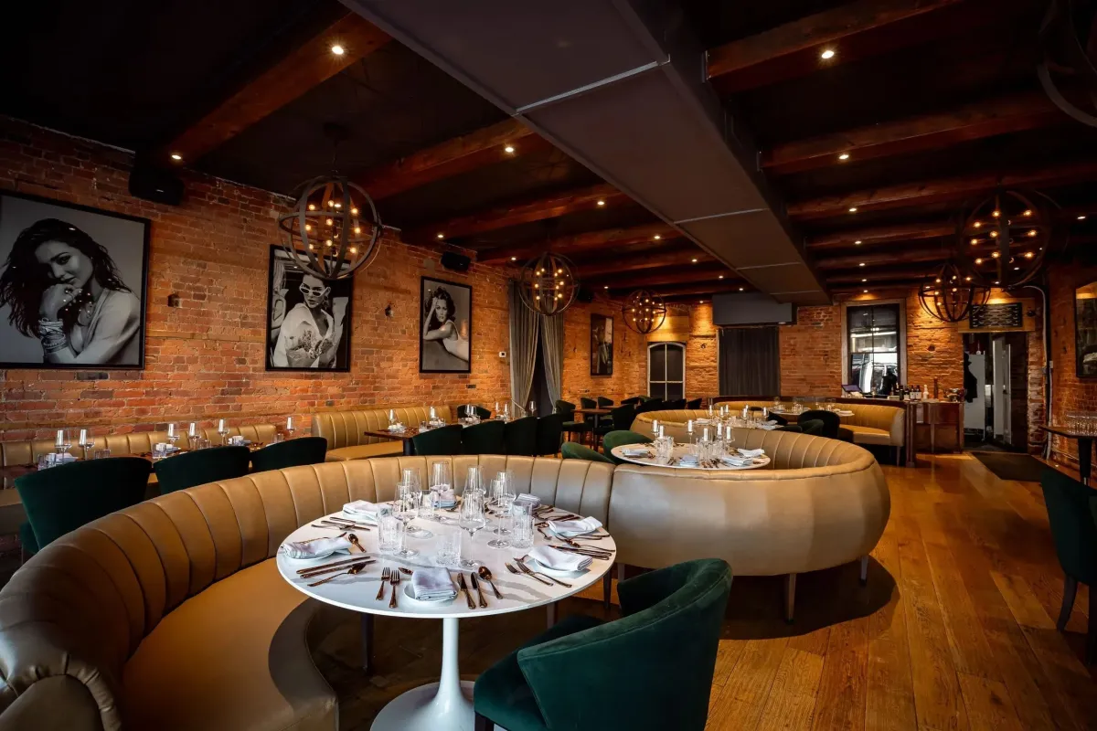 Elegant dining room at Ce Soir Brasserie and Bar with leather booths and warm lighting.