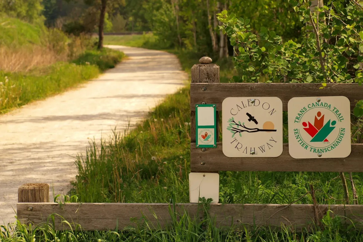 A scenic wooded walking path and entrance sign for the Trans Canada Trail in Oakville.