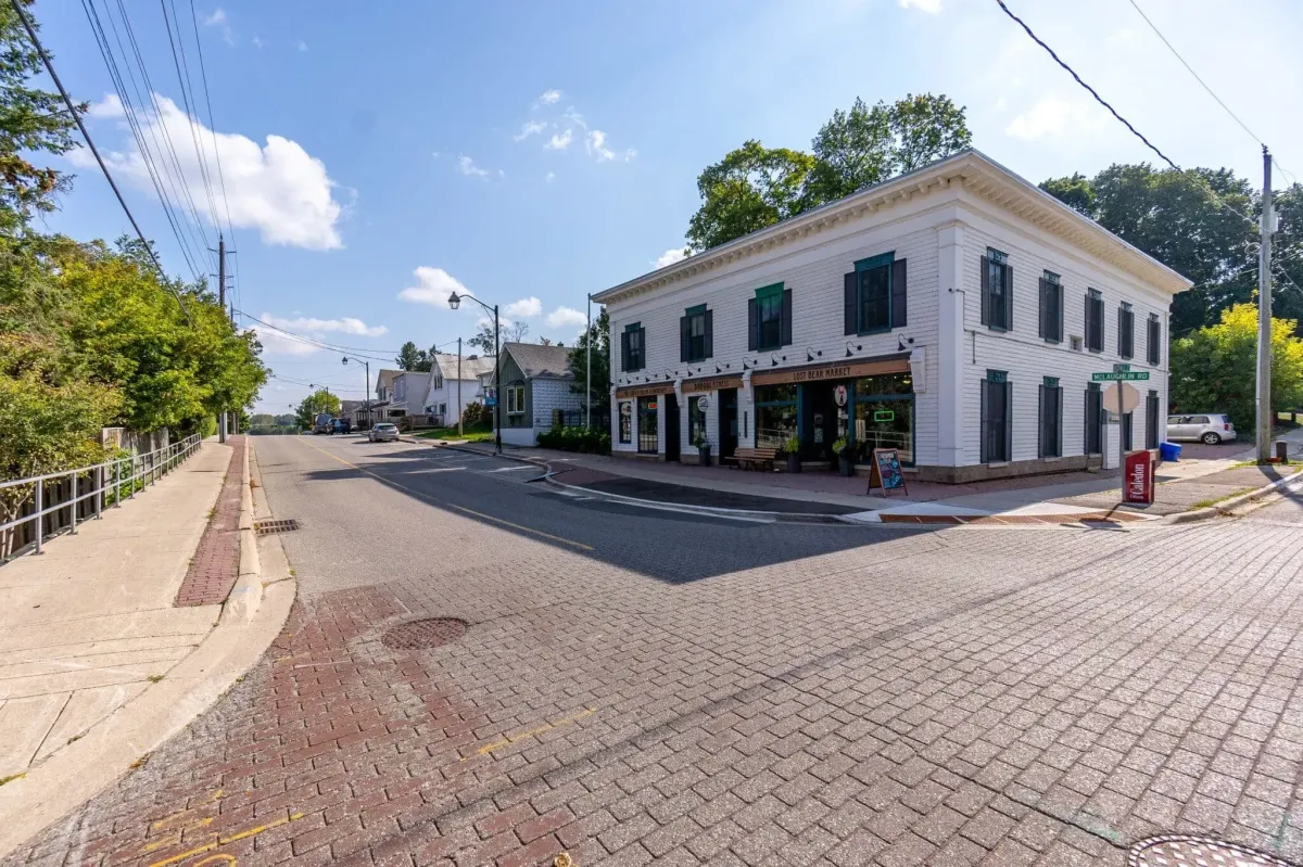 A quiet village intersection and historic white building in Inglewood, Caledon.