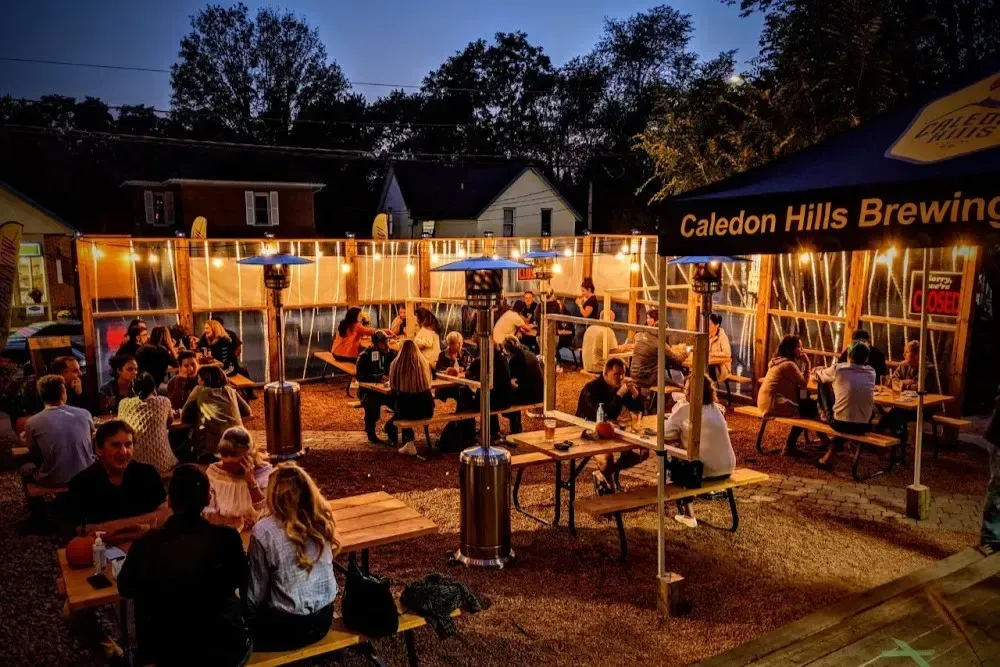 Vibrant outdoor beer garden and patio at Caledon Hills Brewing Company at night.