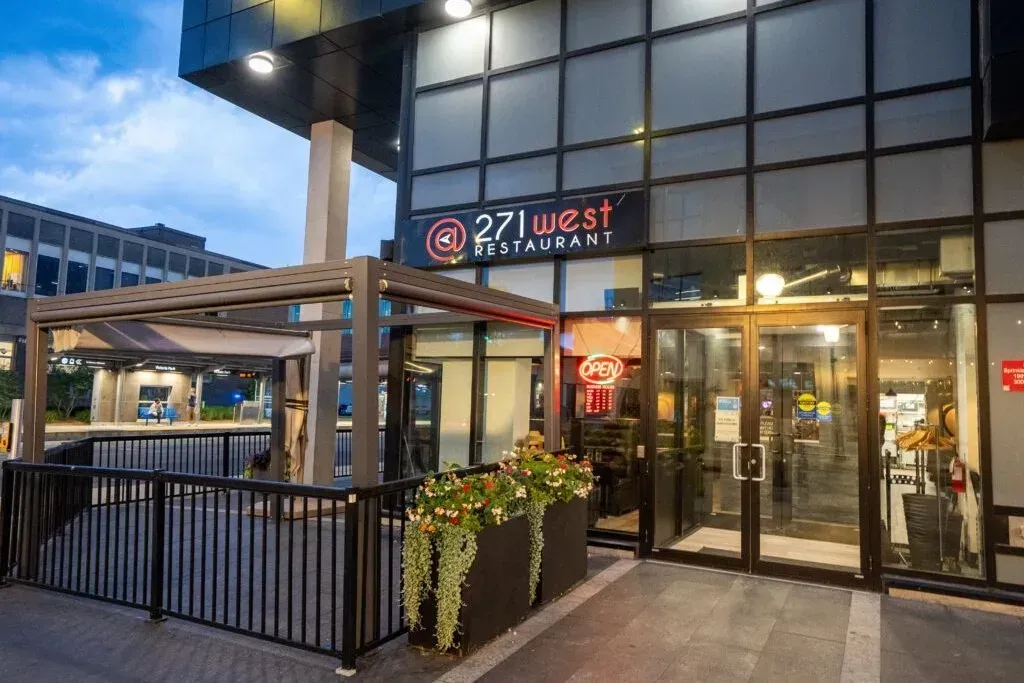 The modern glass exterior and patio entrance of 271 West Restaurant in downtown Kitchener.
