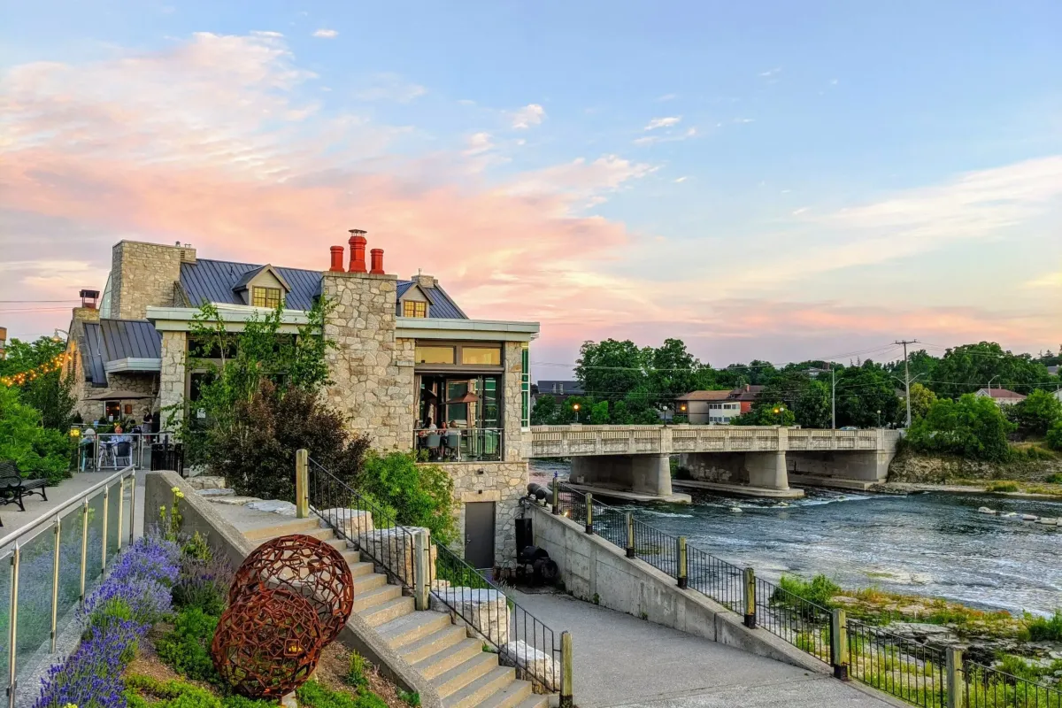 An elegant wooden communal dining table set for a formal meal in a popular Kitchener restaurant.