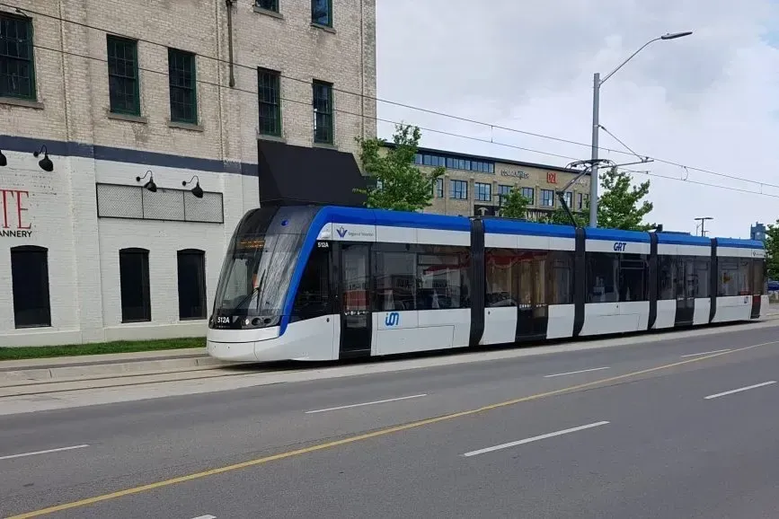 A modern ION light rail vehicle and a Grand River Transit (GRT) bus operating in downtown Kitchener.