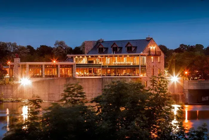 Scenic night view of the historic Cambridge Mill restaurant overlooking the Grand River in the Galt district.