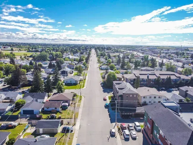 Aerial perspective of Forest Lawn in SE Calgary, showing a long residential thoroughfare.