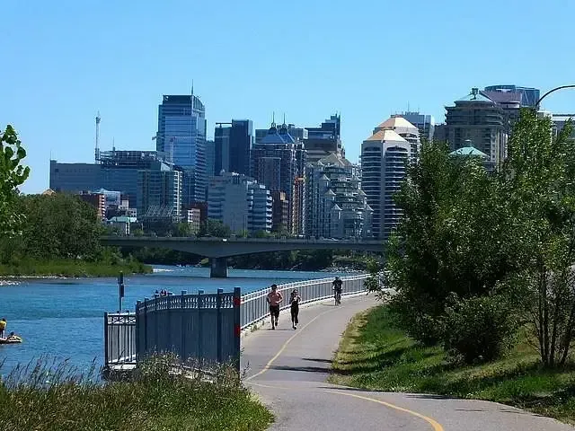 Paved riverside trails along the Bow River with the Calgary city skyline in the background.