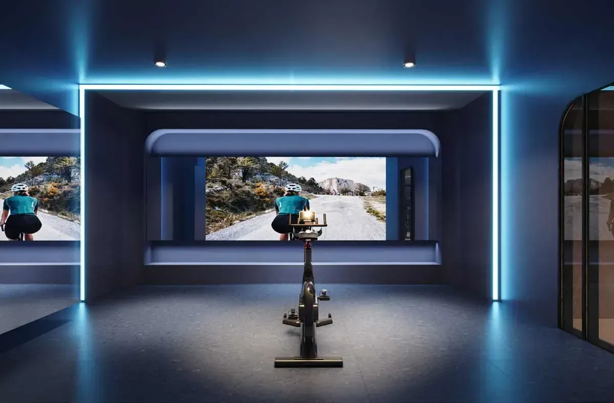 Modern virtual cycling and spin studio with neon accent lighting at Joya Condos wellness centre.