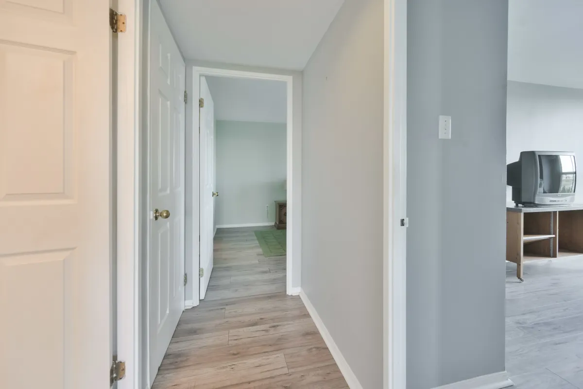 View from the hallway looking into the bright secondary bedroom.