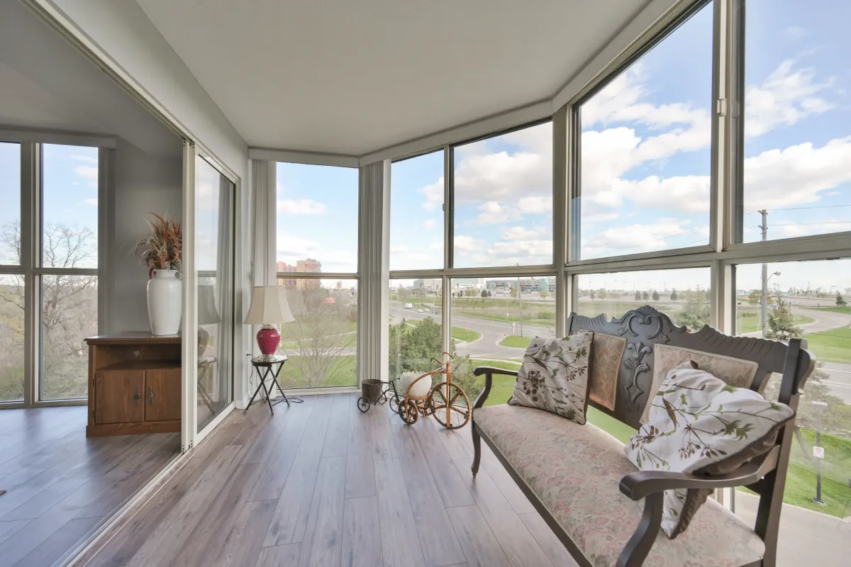 Sun-filled sunroom seating area with panoramic views in an Etobicoke condo.