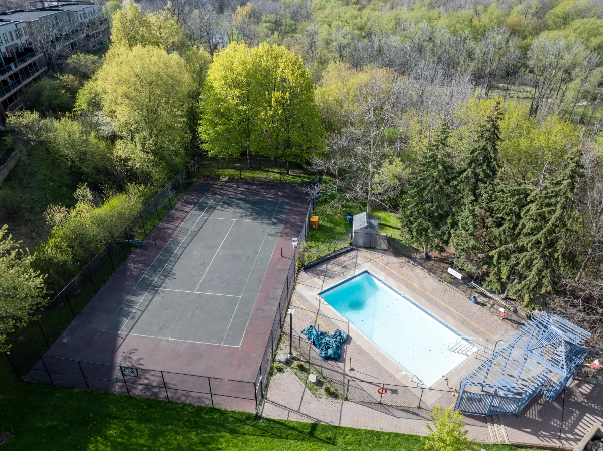 Close-up aerial of the private resident swimming pool and tennis courts.
