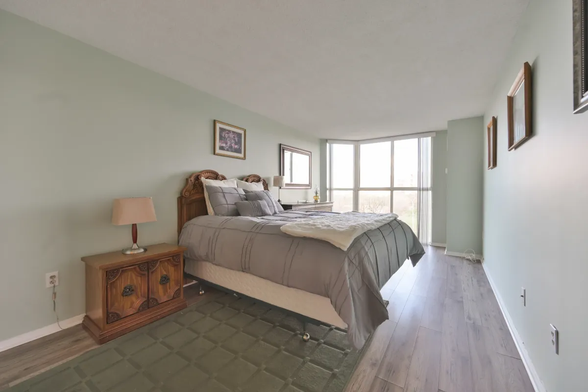 Large primary bedroom with neutral decor and a large window for natural light.