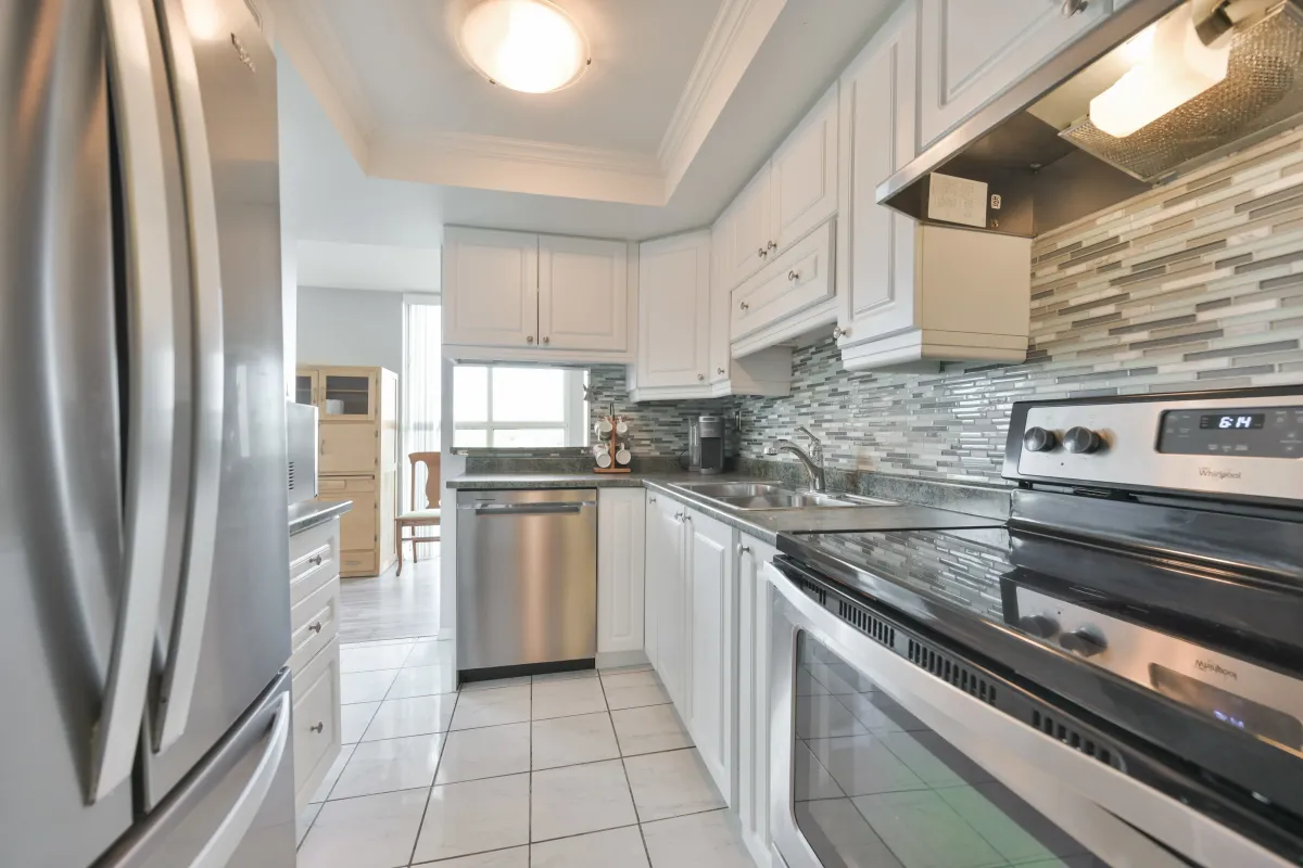 Functional walk-through kitchen with modern finishes and ample cupboard space at 600 Rexdale.