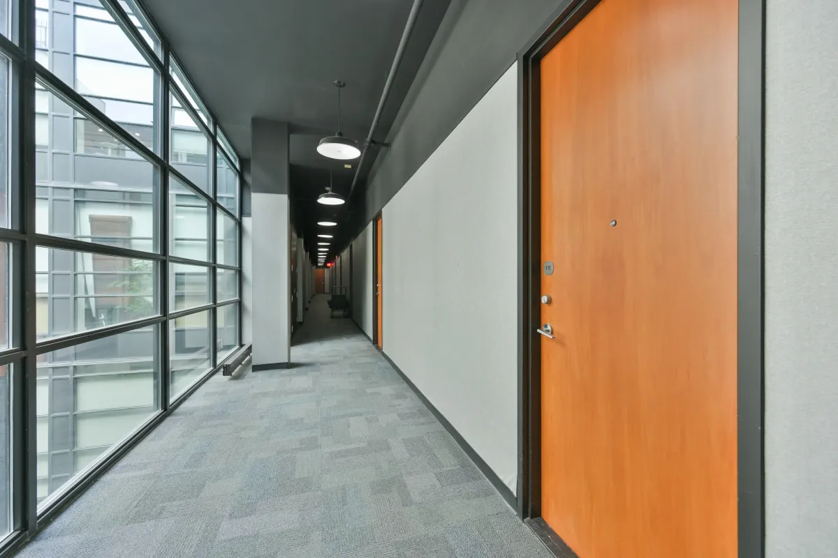 Bright interior residential hallway with a wood-finish unit door at 61843 Hanna Ave.