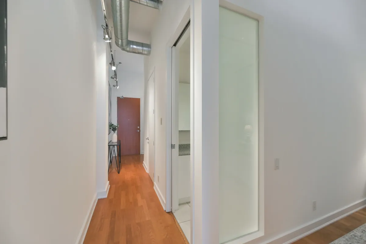 Bright white interior hallway leading into the main living spaces of 61843 Hanna Ave.