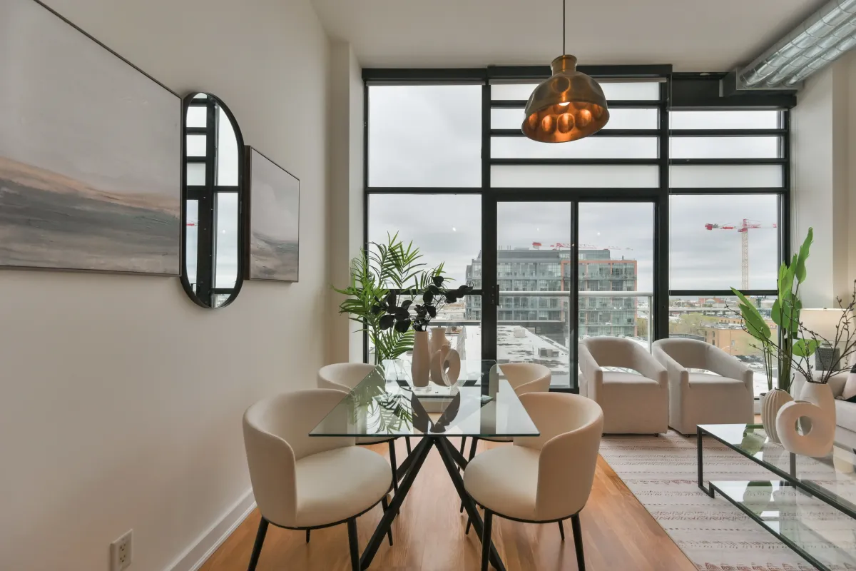 Living room overlooking the city through large industrial loft windows at 61843 Hanna Ave.