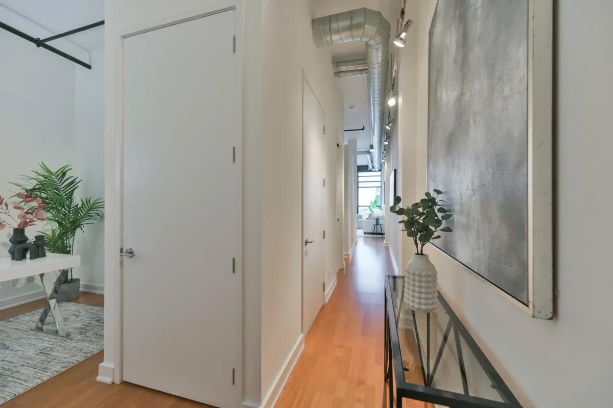 Minimalist white hallway inside the loft with exposed industrial ductwork at 61843 Hanna Ave.