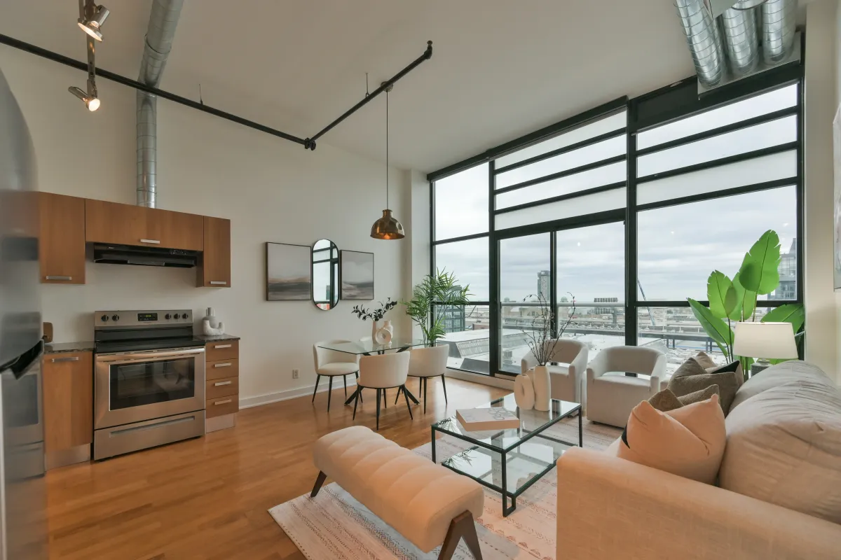 Open-concept living room and kitchen area with large warehouse windows at 61843 Hanna Ave.