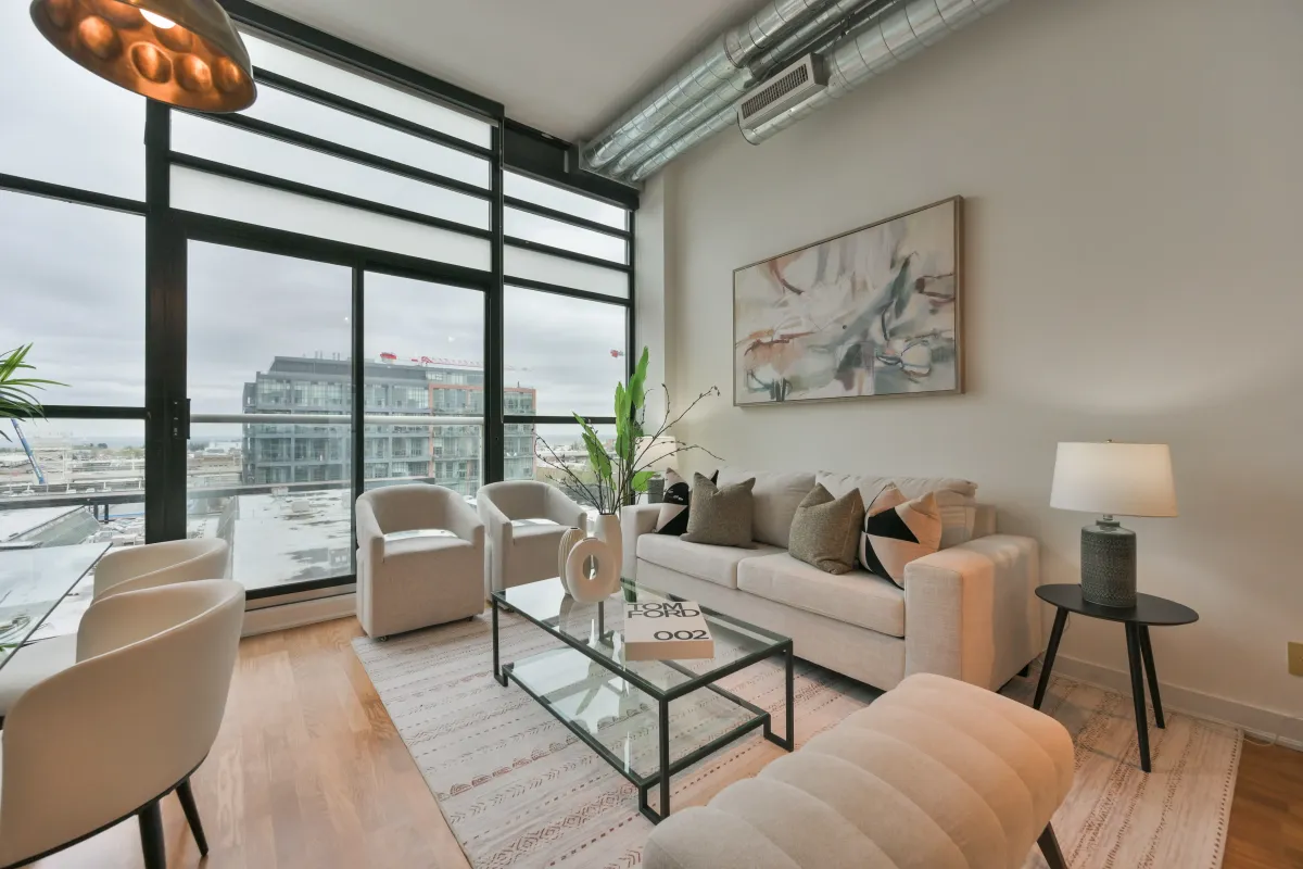 Bright loft living room with massive multi-pane windows and track lighting at 61843 Hanna Ave.