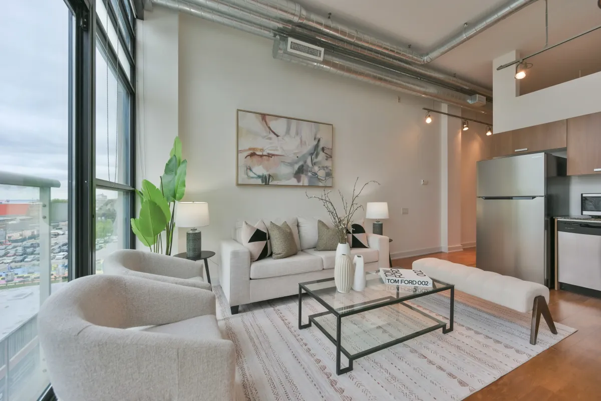 Spacious industrial loft living room with white walls and exposed piping at 61843 Hanna Ave.