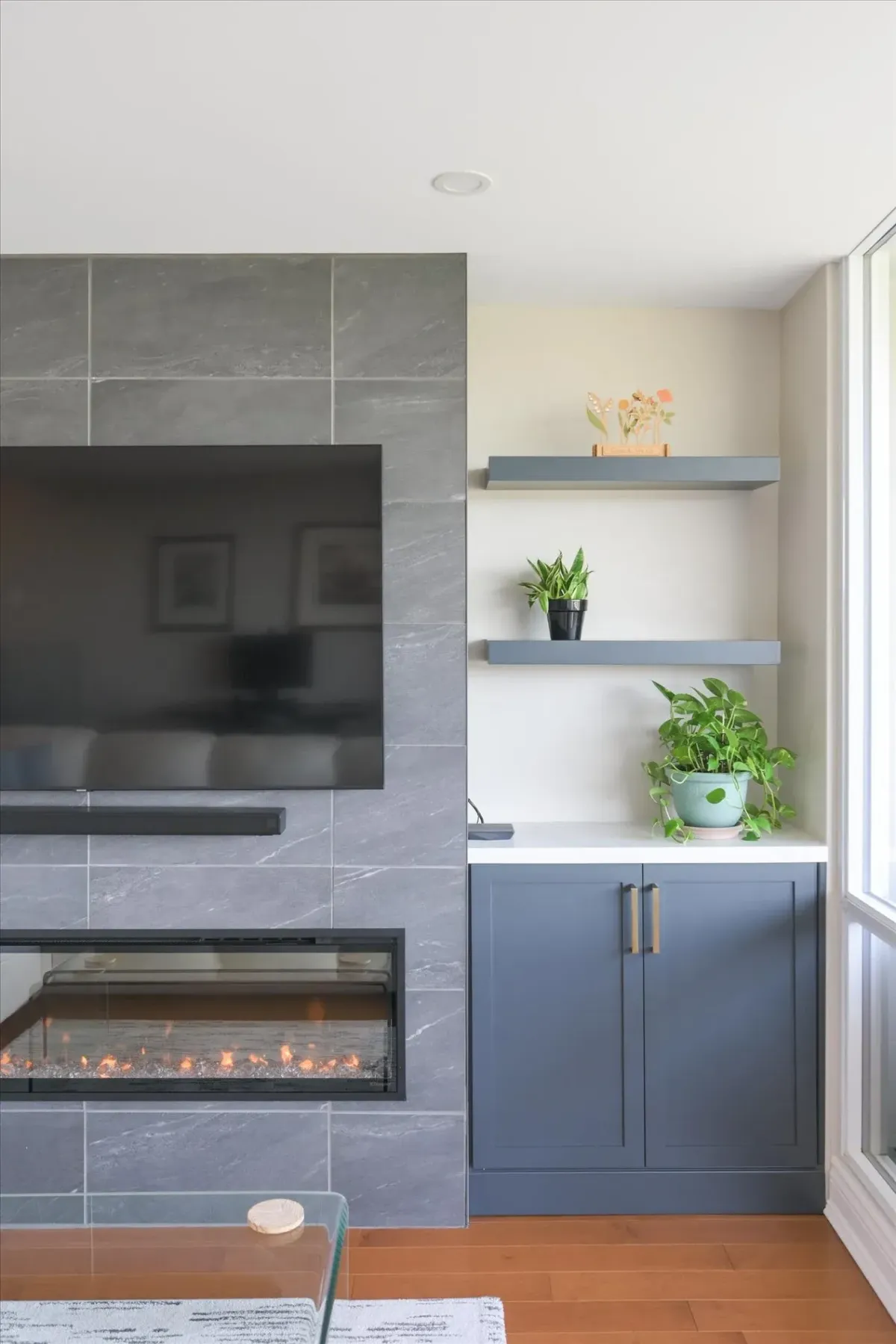 Detail view of the integrated fireplace, TV mount, and built-in lower storage cabinets at 240 Scarlett Rd #912.