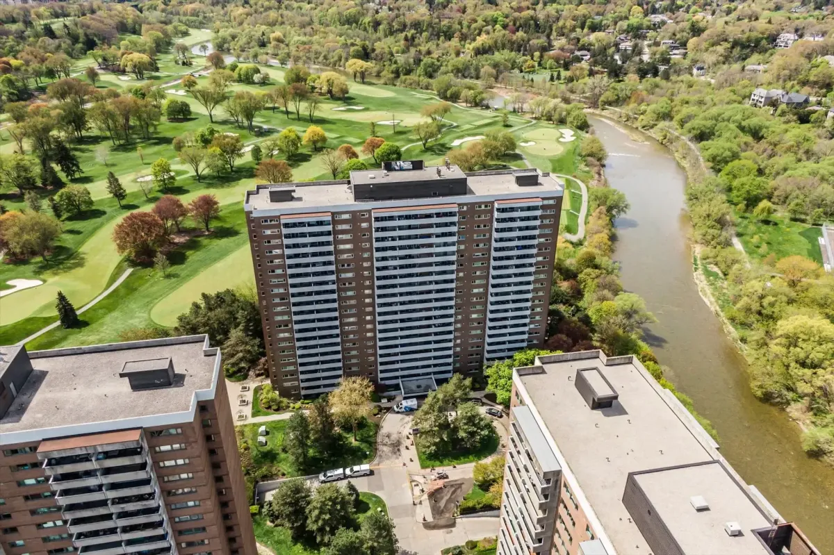 Bird's-eye view of the high-rise residential tower at 240 Scarlett Rd #912 next to a golf course and river.