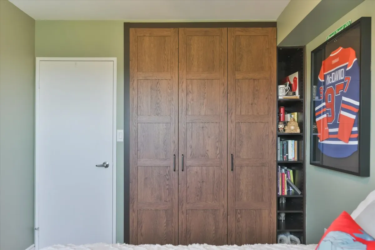 Large wood-grain storage wardrobe built into the wall of the second bedroom at 240 Scarlett Rd #912.