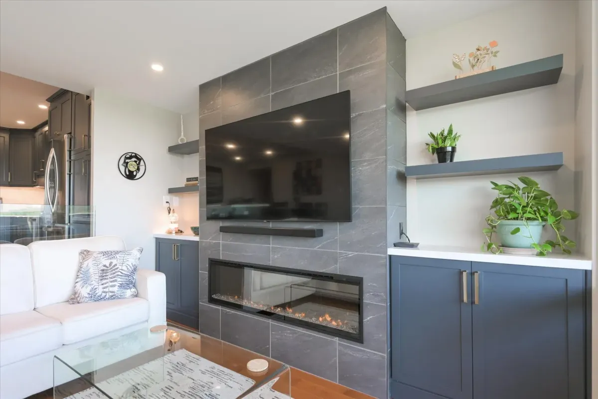Close-up of the modern grey tiled fireplace accent wall with custom floating wood shelves at 240 Scarlett Rd #912.